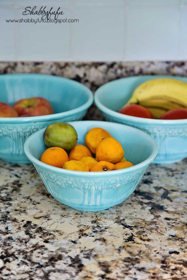 Adding pops of color to a room - light blue pottery contrasts with lemons, limes, and oranges