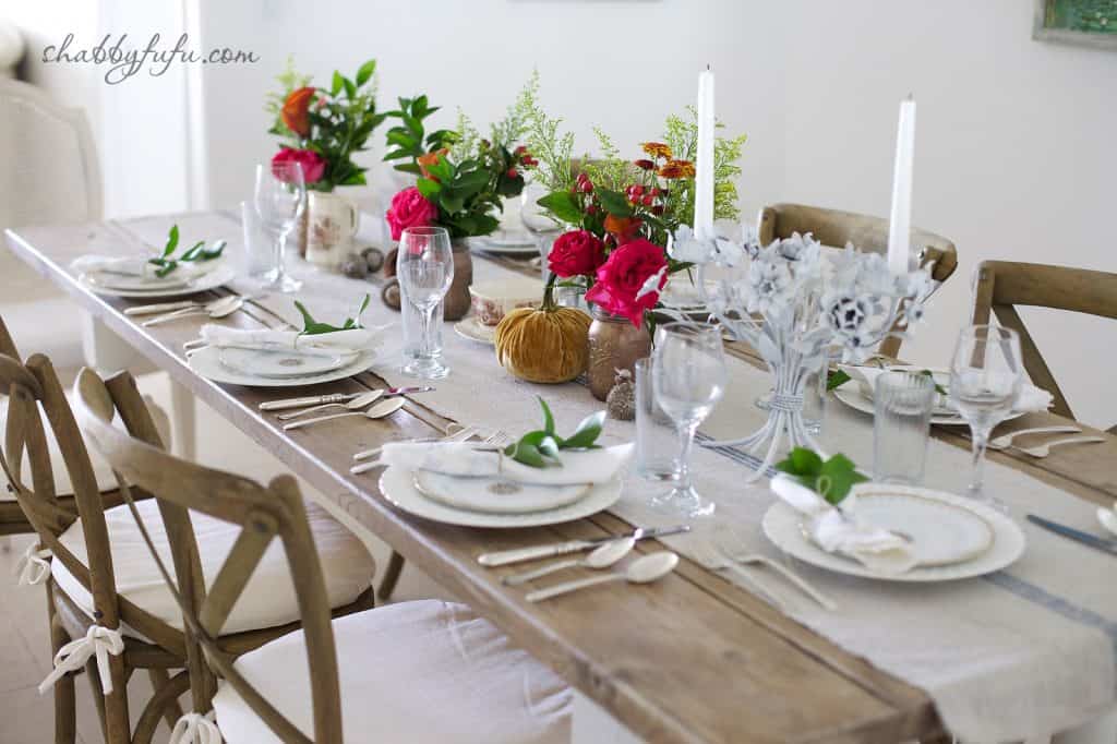 Thanksgiving Beach House decor - tablescape with white cloth runner and bright fall flower centerpieces