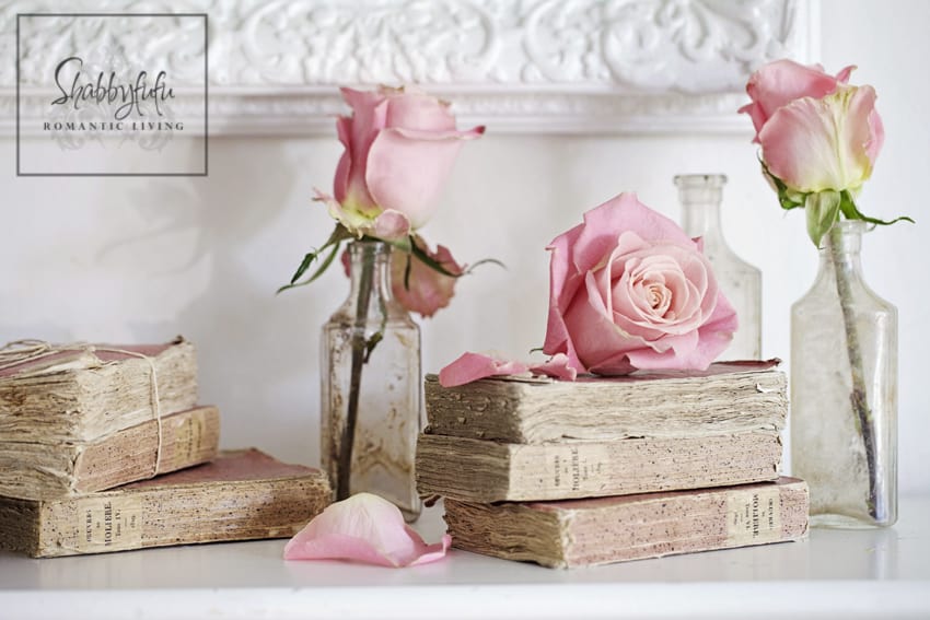 romantic room designs - blush pink roses displayed on vintage books on a bedroom mantel