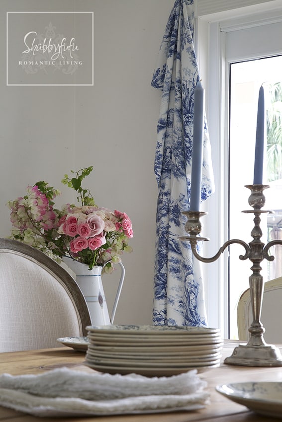 Decorating with toile - toile curtains, a bright pink floral bouquet and elegant blue candlesticks 