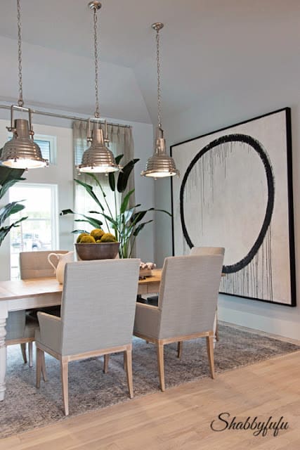 A modern style painting of a giant black circle hangs on the wall in the dining room of the HGTV Dream Home 2016.
