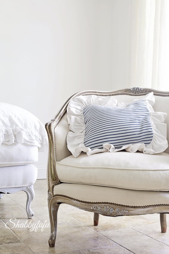 blue and white ticking stripe pillow on a french bergere chair