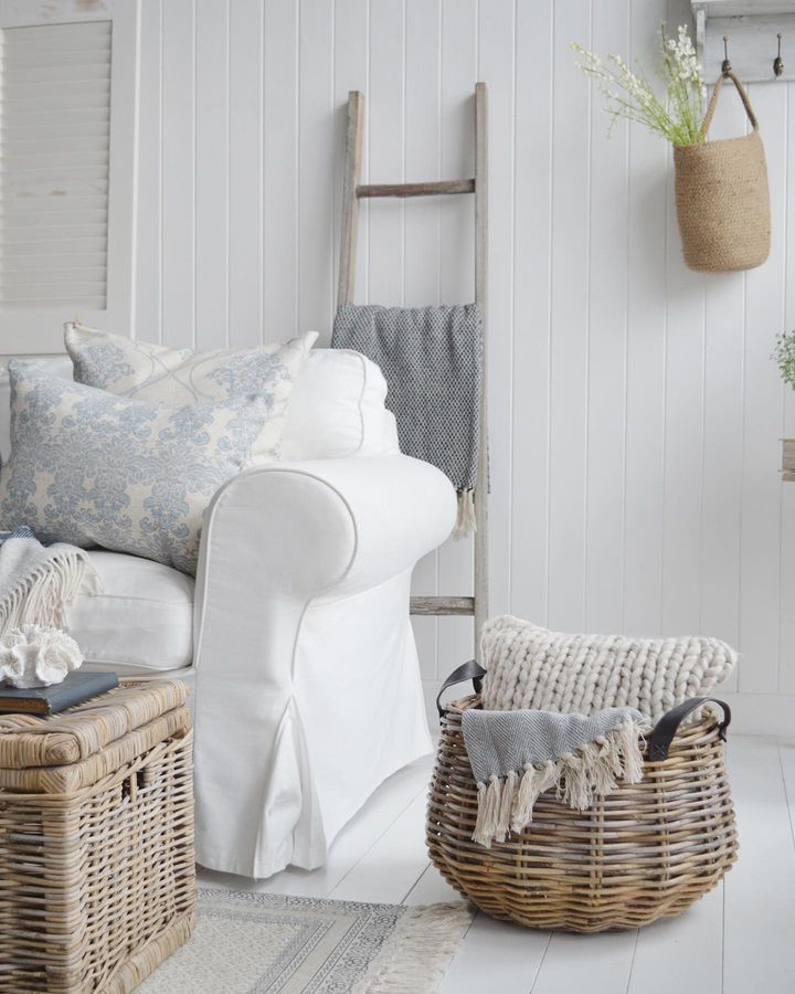 white decorating tips featuring a  living room with a white couch and floors, along with baskets and wooden stairs, via @thewhitelighthouse