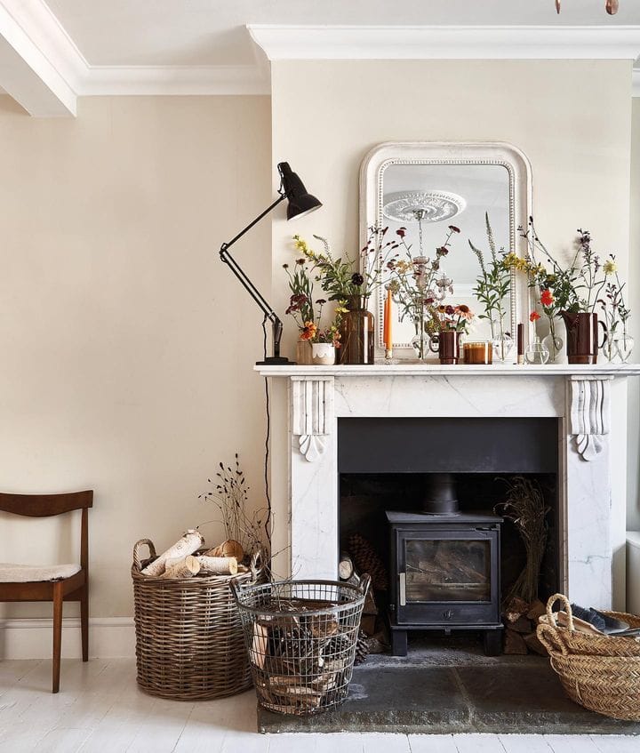 inspiration for how to shop in thrift stores for a beautiful home featuring a living room with a fireplace in the background and baskets next to it