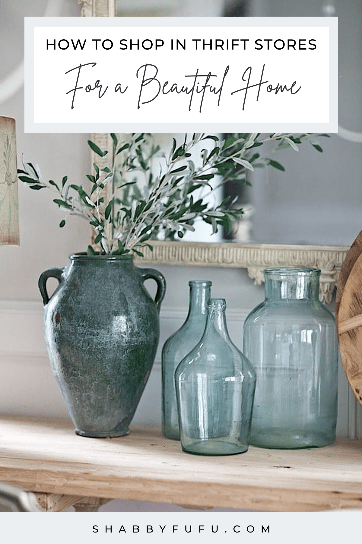 Pinterest image with the text "How To Shop In Thrift Stores For a Beautiful  Home" featuring glass and ceramic vases with dried eucalyptus stems.