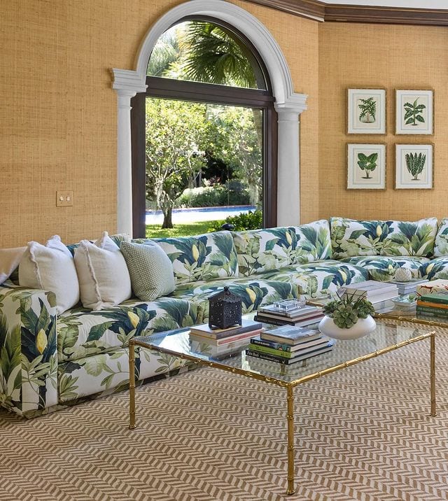 palm tree home decor trends featuring a living room with framed palm tree leaves artwork and patterned sofa