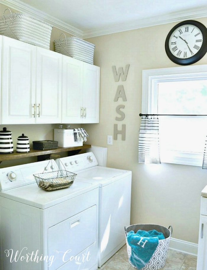 white washer and dryer with white cabinets above