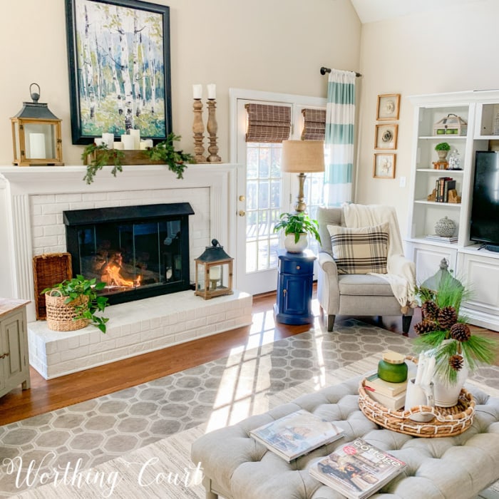 family room with white fireplace and gray recliner in corner with art and accessories