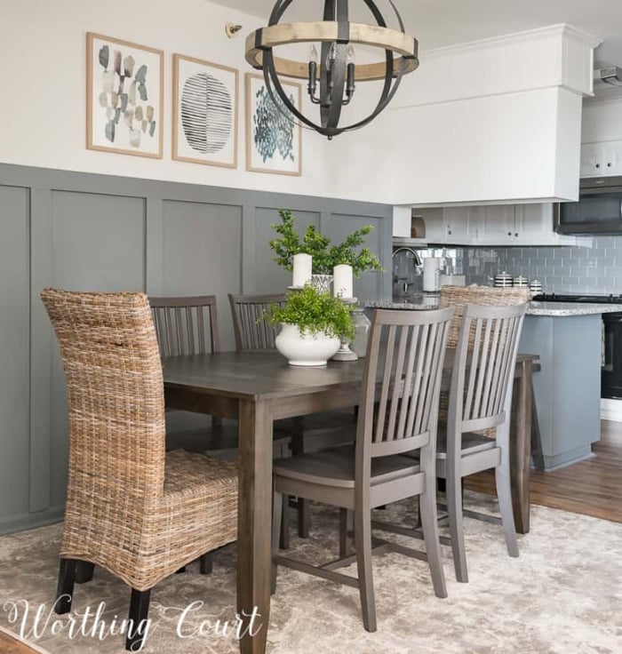 dining room area with table with 6 chairs, a modern chandelier and gray board and batten wall