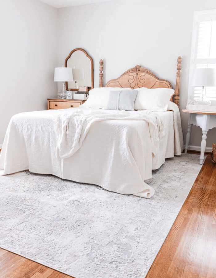 elegant and airy farmhouse bedroom featuring a large bed in creamy hues