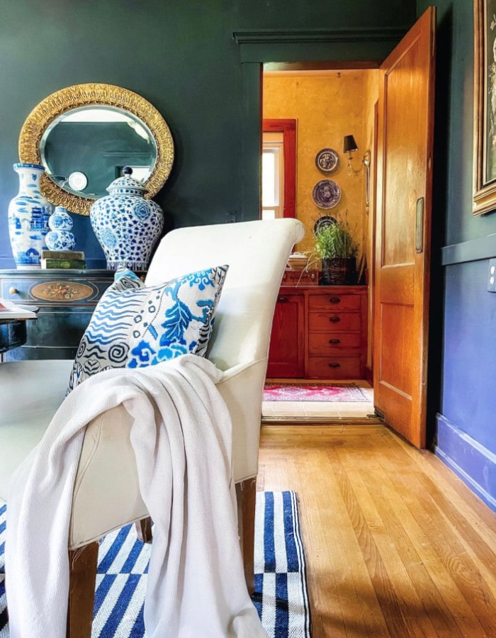 grandmillennial farmhouse inspired home in NY featuring white and blue rug, dark blue walls and traditional chinoiserie decor elements 