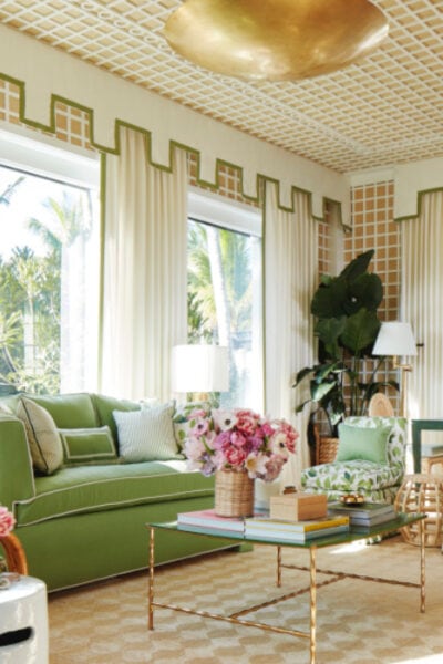 palm beach inspired living room decor featuring a green sofa, golden lamps and coffee table