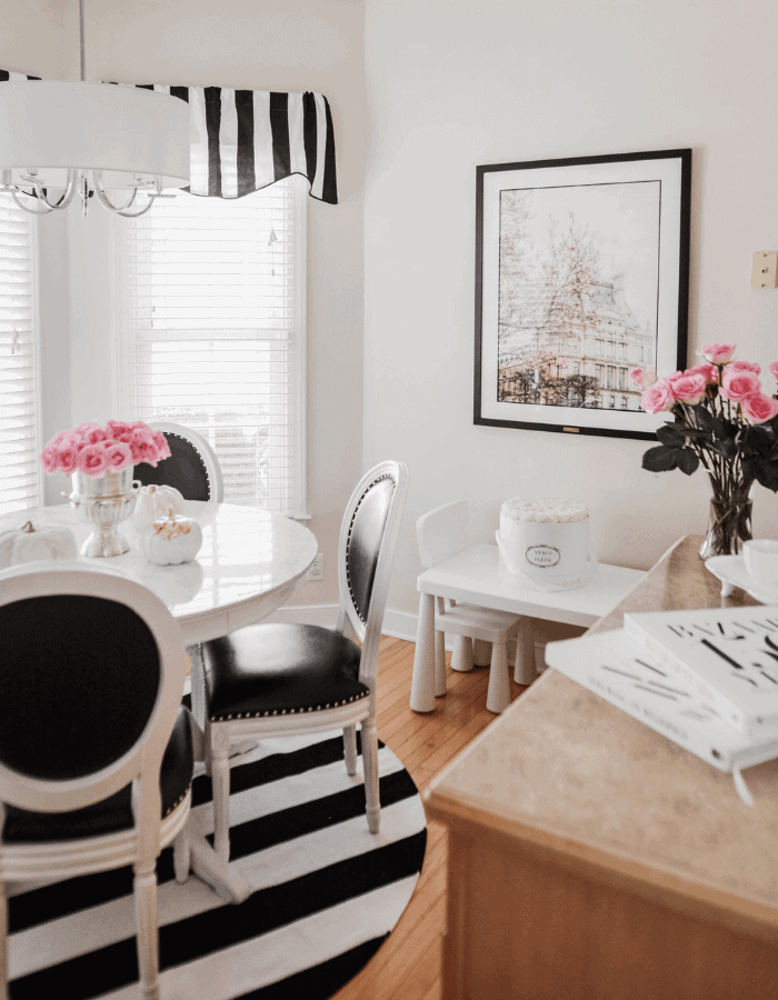 Bistro inspired kitchen nook featuring black and white striped rugs and curtains
