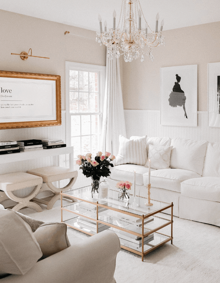 sophisticated french inspired living room made of white sofas, black and white illustrations and flowers