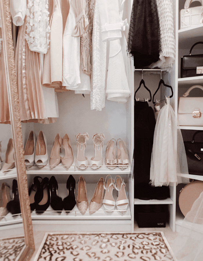 small closet in modern glam style with pink, black and white dresses and high heels