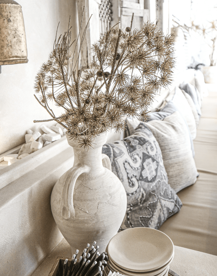 neutral home decorating ideas showing a living room with a ceramic vase and dried flowers in warm neutrals