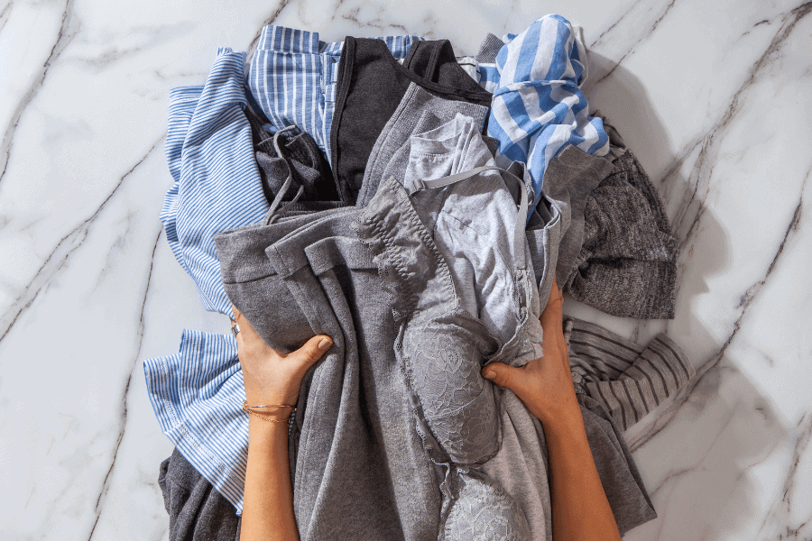 hands holding clothing pile