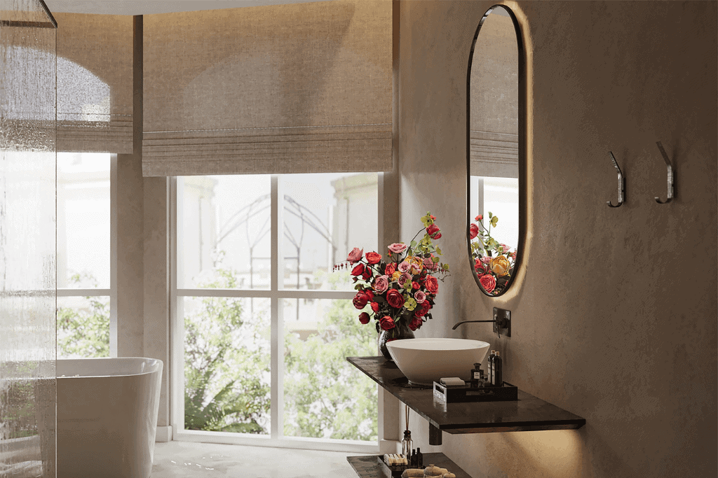 A bathroom with a large window featuring roller shades as the window treatments.