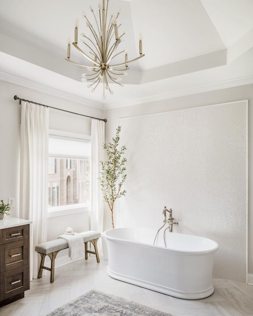 elegant bathroom featuring a large bathtub next to a large window with draped sheer curtains