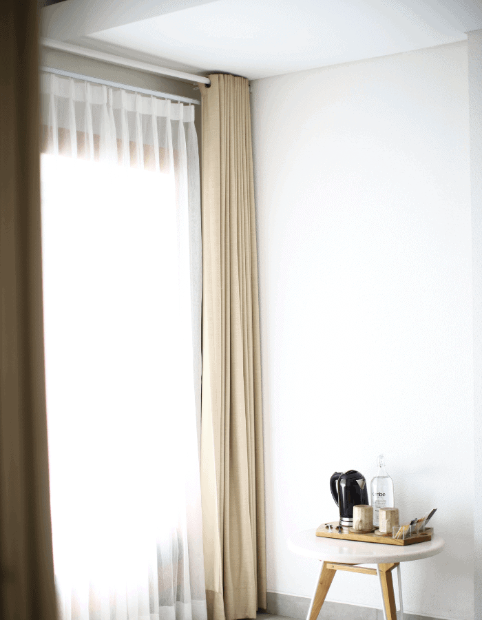 Large window featuring a window treatments of double curtains