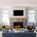 Ideas of a coastal cottage inspired living room featuring a stone wall fireplace