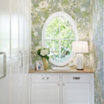 cottage coastal storage closet featuring built-in shelves and floral wallpaper
