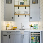coastal cottage home bar featuring built in furniture cabinets in light grey