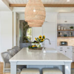 kitchen island in coastal cottage featuring raffia woven pendant lights