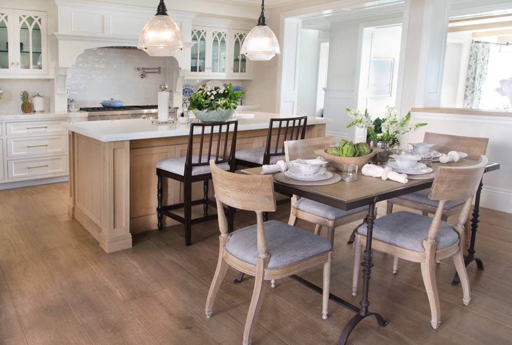 dining space featuring farmhouse table and chairs with kitchen in the background