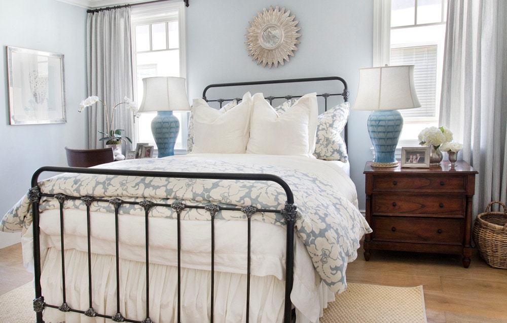 bedroom in a cozy coastal home featuring white and blue pillows