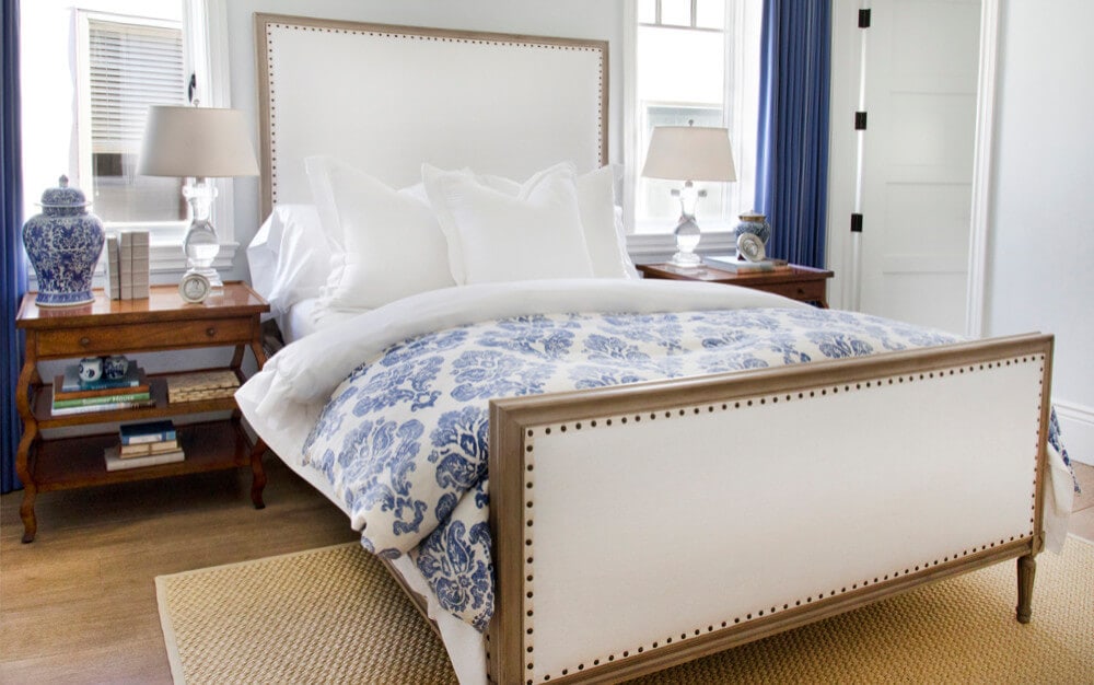 bedroom in a cozy coastal home featuring white and blue pillows