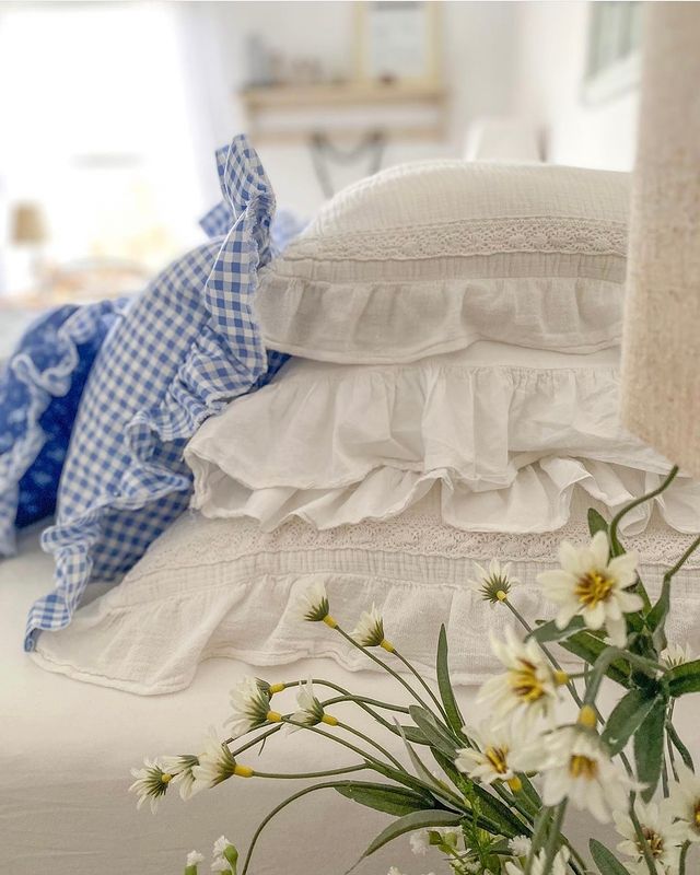 cottage style bedroom featuring close up of a bed with bedding in white and blue
