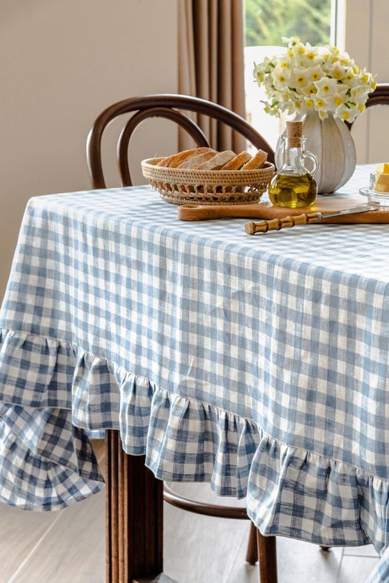 cottage dining table featuring a tablecloth in a white and blue checkered pattern
