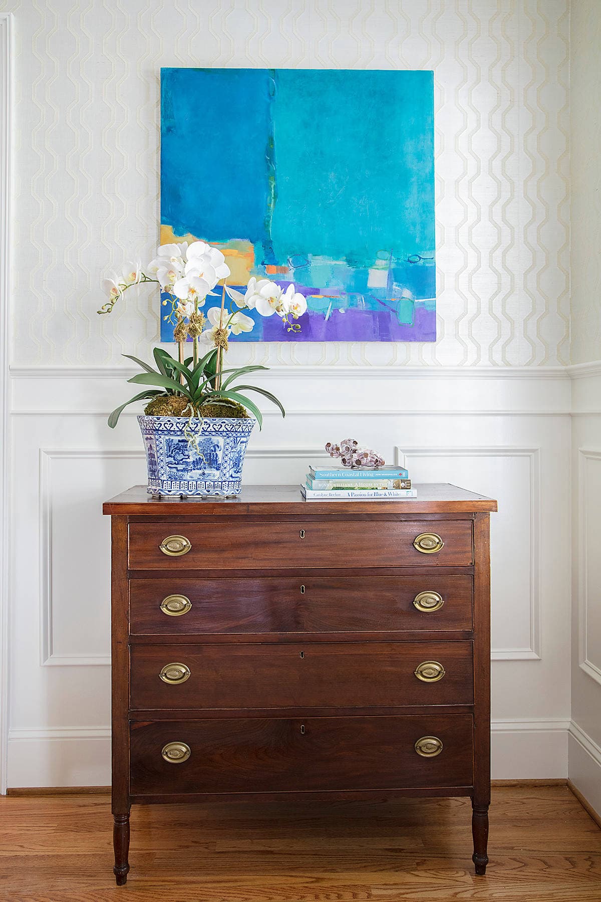 Home tour: Chest drawer in dark wood with a colorful artwork above it