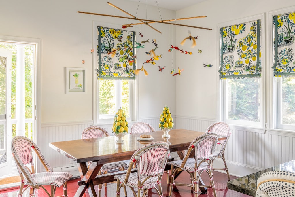 Dining room featuring hanging mobile and white and red bistro chairs