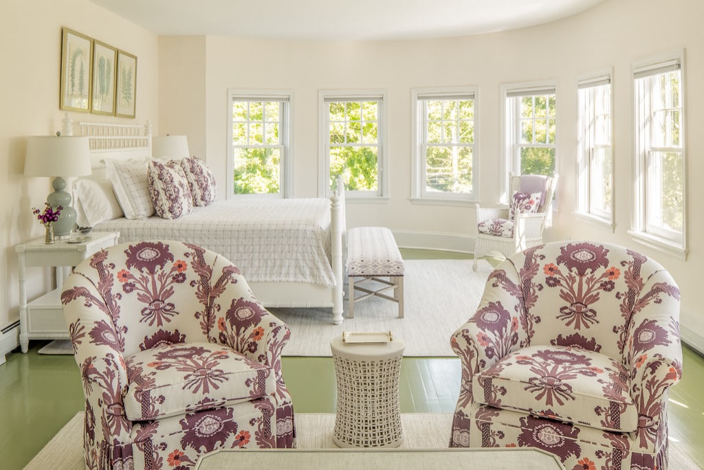 Bedroom in beach style home tour featuring armchairs in purple and cream pattern