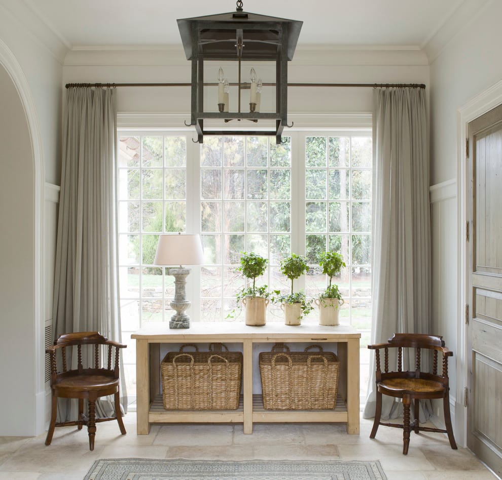 Traditional style home tour featuring a console table with baskets and next to it, one chair on each side.