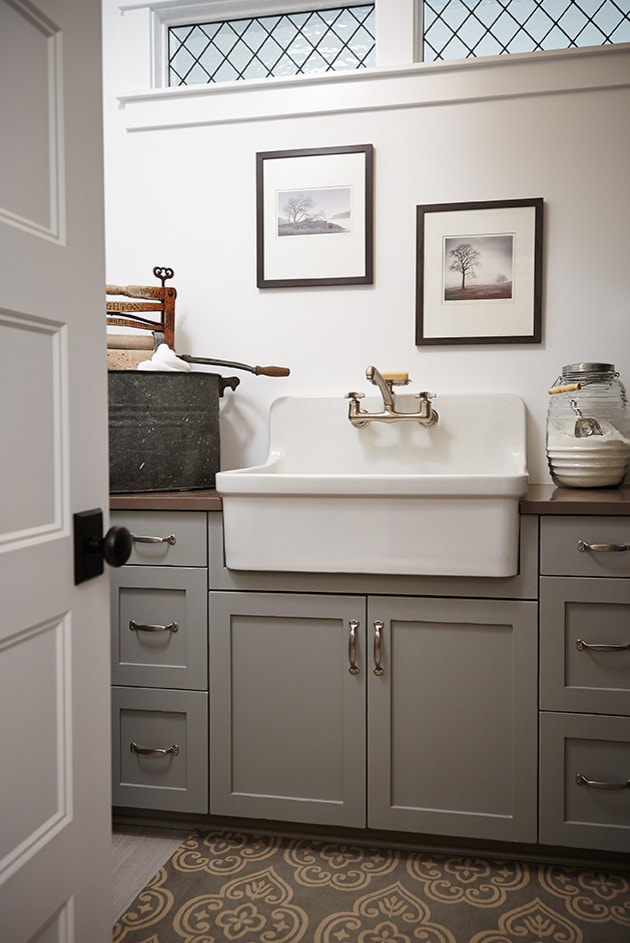 Laundry room featuring farmhouse style decorative items and sink in traditional home tour