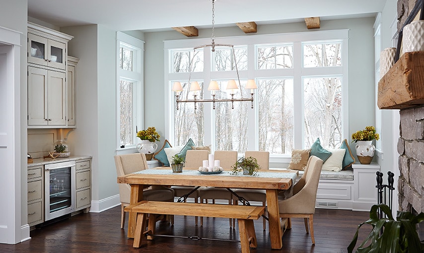dining desk featuring natural dining table with a bay window behind it, home tour