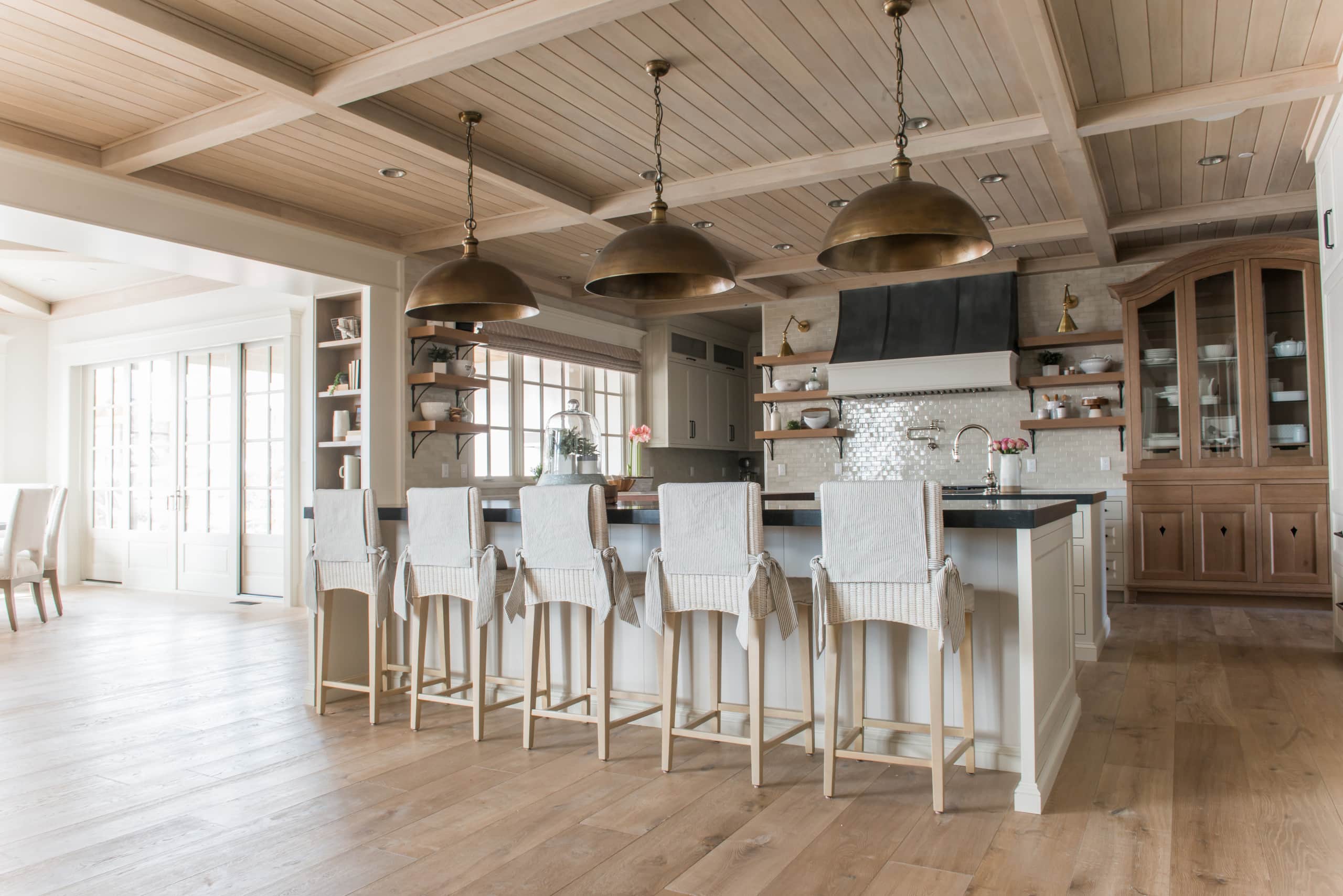 European style home tour kitchen featuring kitchen island, pendant lights and bar stools