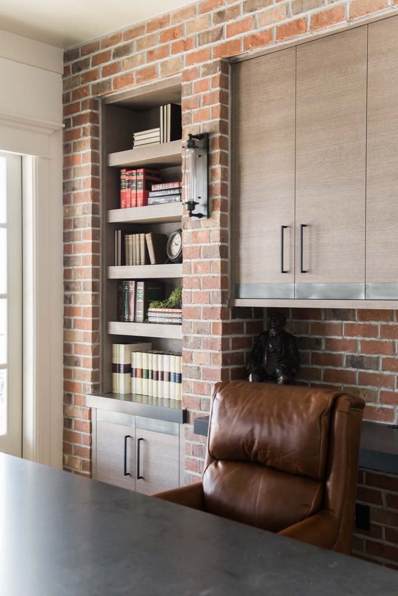 European style home tour featuring an office room with exposed brick wall and brown leaher desk chair