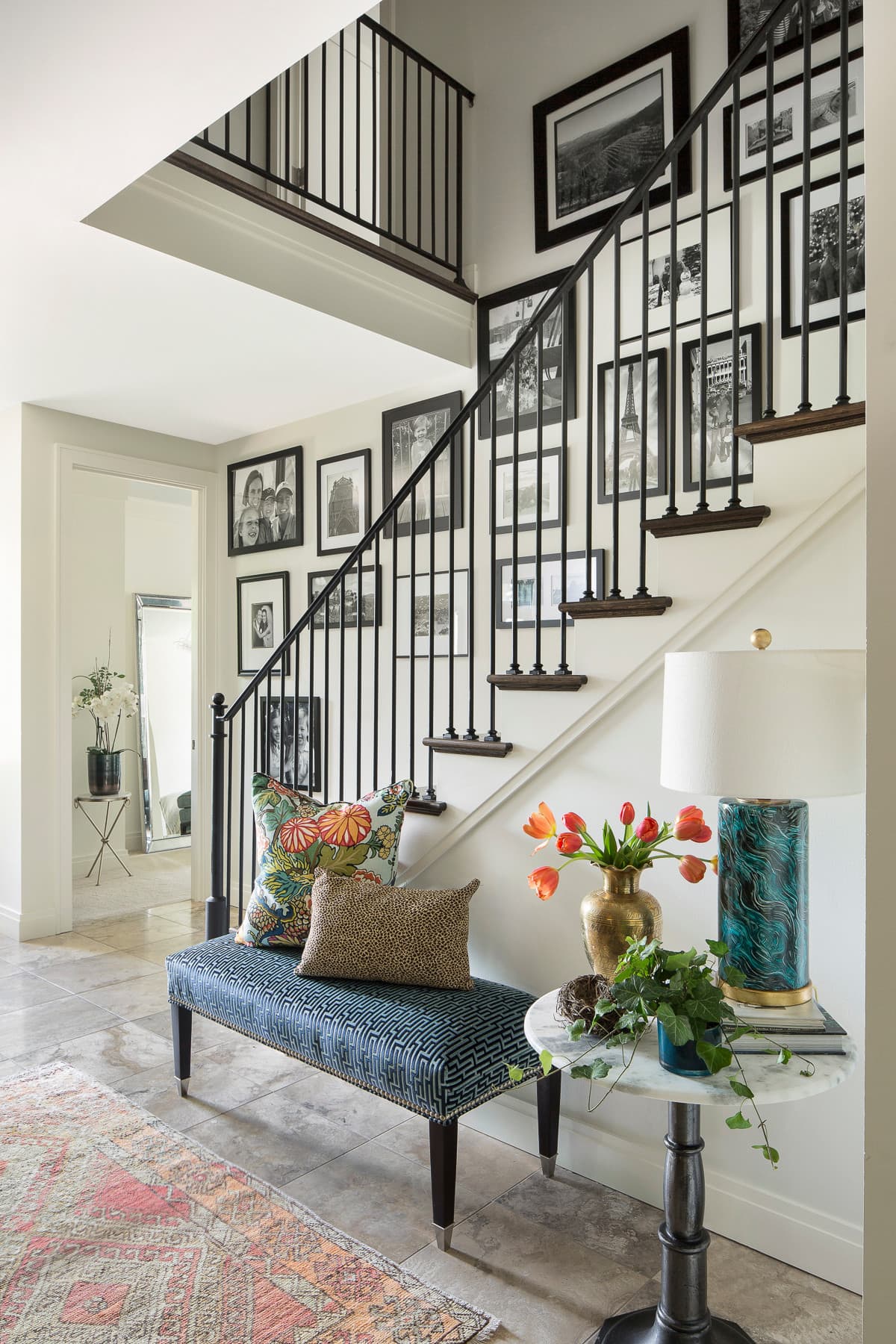 Traditional home tour featuring entry foyer featuring bench, rug, flowers and starcase railway