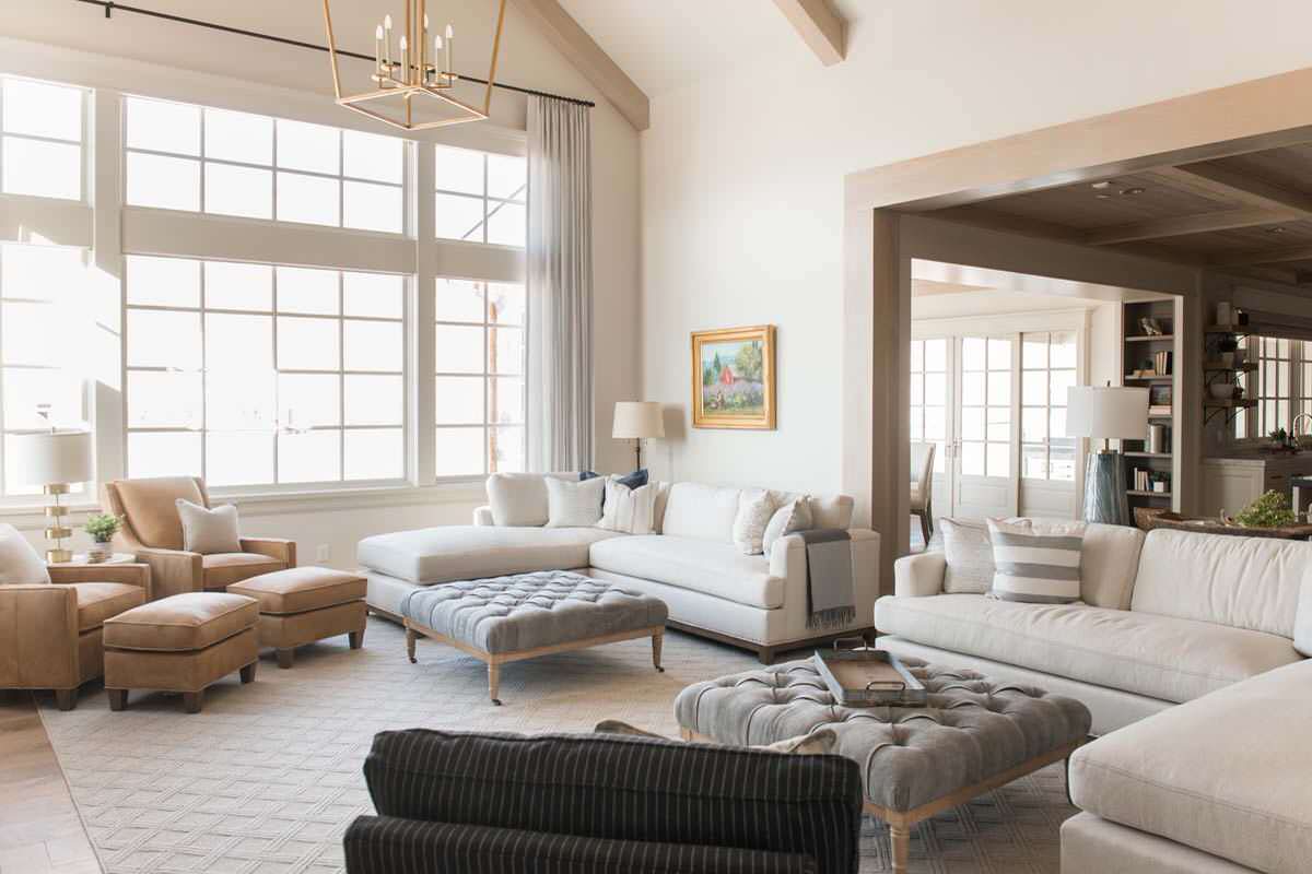 European style home tour living room featuring large windows, ottomans, sofas and armchairs
