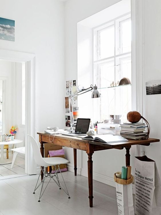 Home office workspace idea featuring a vintage desk flushed against a window