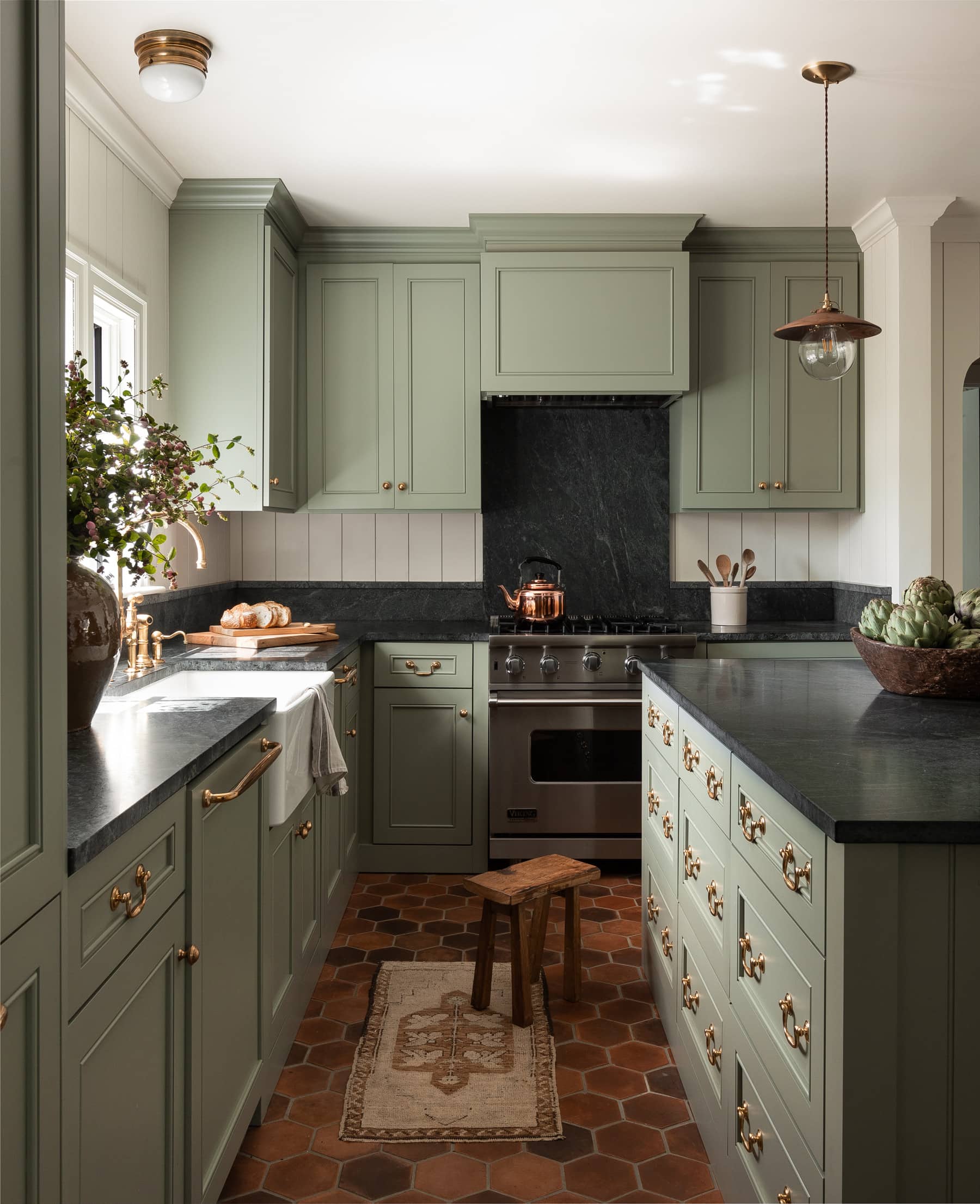 home tour featuring kitchen in sage green showcasing a black marble kitchen island in a vintage cottage decor