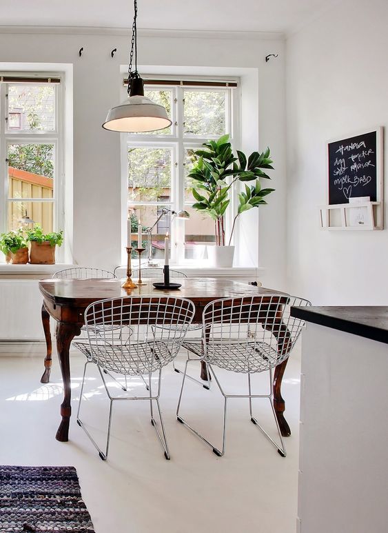 Mixing vintage and antiques in modern spaces idea featuring an open concept kitchen with a dark wood vintage table next to modern chairs