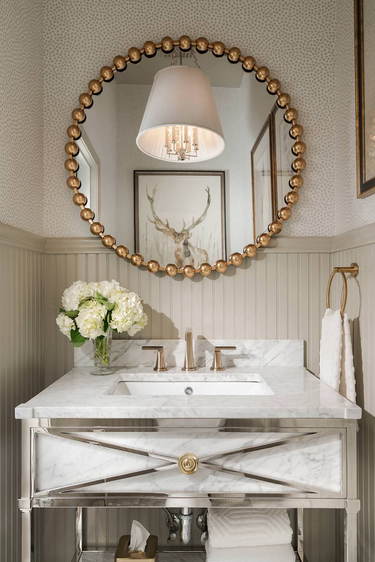 living room from home tour featured in a english cottage styled home, showcasing powder room in soft neutral colors and gold round mirror