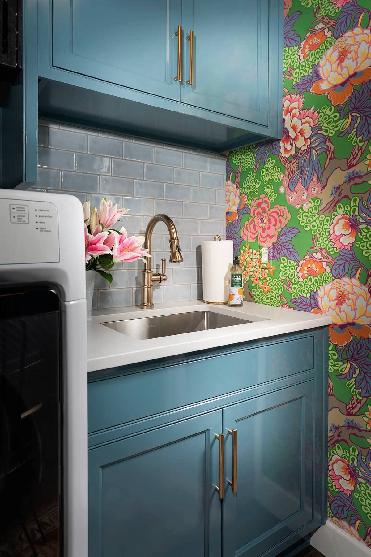 laundry room from home tour featured in a english cottage styled home, showcasing sink and blue cabinets