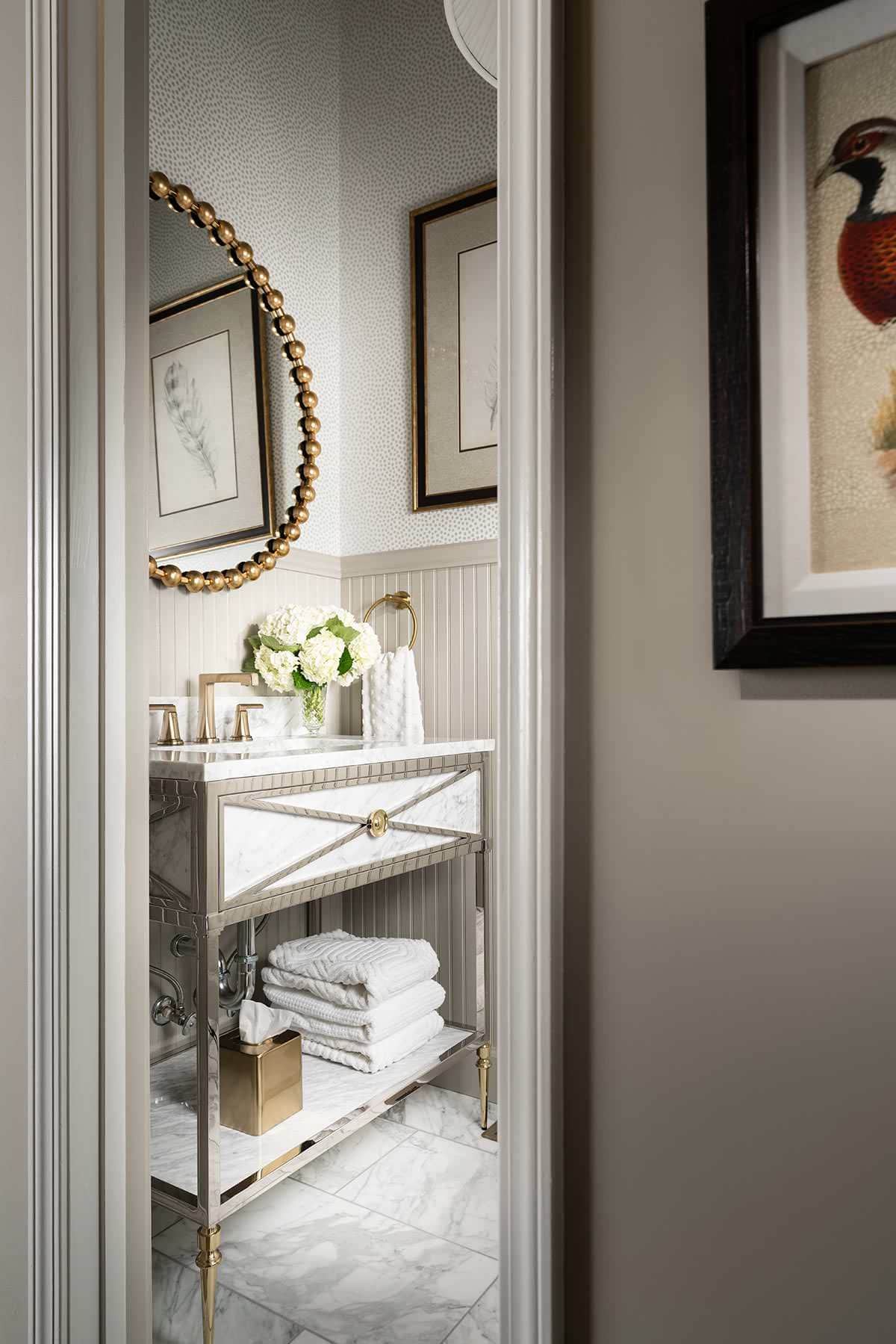 powder room from home tour featured in a english cottage styled home, showcasing powder room in soft neutral colors and gold round mirror