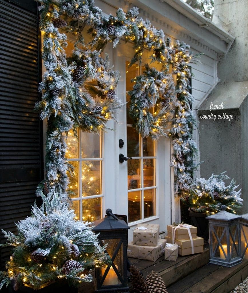 Front door with snowy greenery garlands featured outdoor decorating ideas